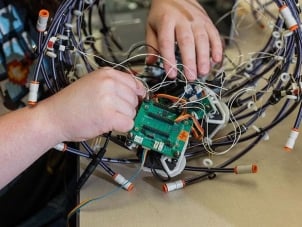 A mechanical engineering student working on mechanical device.