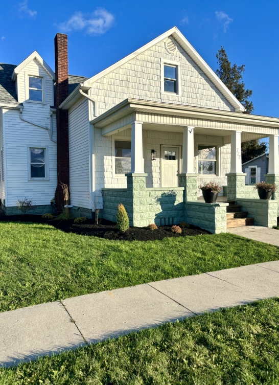 Workers reviewing building plans on a table with tools and blueprints.