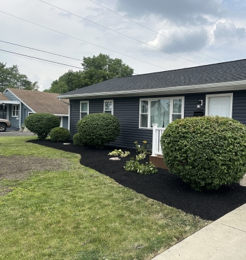 Modern white kitchen with island, stainless steel appliances, and pendant lighting.