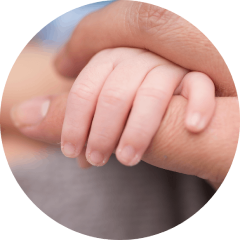 Kleine Babyhand umschließt Finger