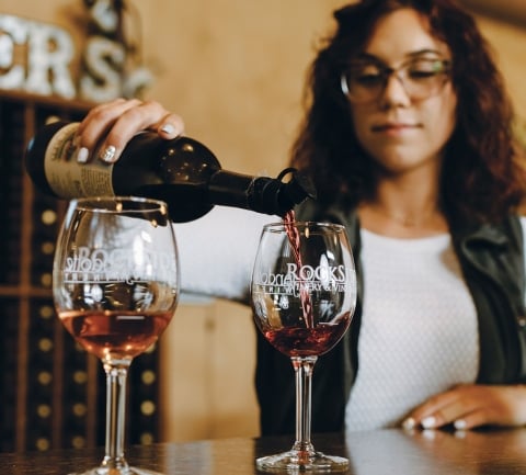 Woman pouring red wine in a glass
