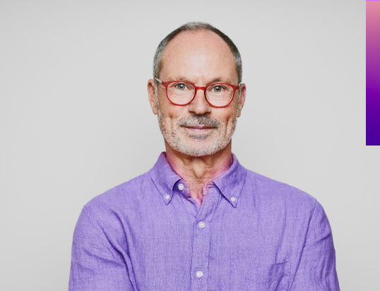 man wearing grey suit with arms crossed. purple decorative line