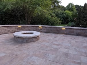 paver patio with firepit and lights