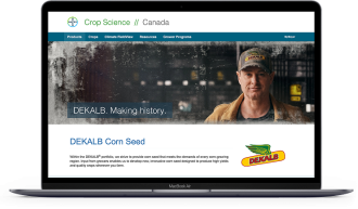 A laptop sitting open with the Bayer Crop Science Canada website’s homepage visible.