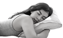 A woman sleeping peacefully on her bed, enjoying relief from insomnia with Bowen therapy in one session.  