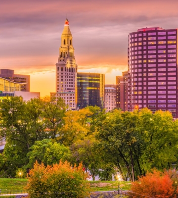 Aerial view of Phoenix neighborhoods with downtown skyline and mountains in the background.