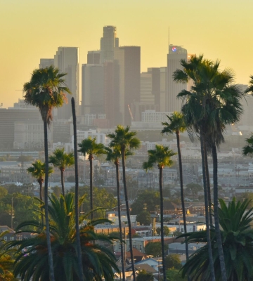 Aerial view of Phoenix neighborhoods with downtown skyline and mountains in the background.