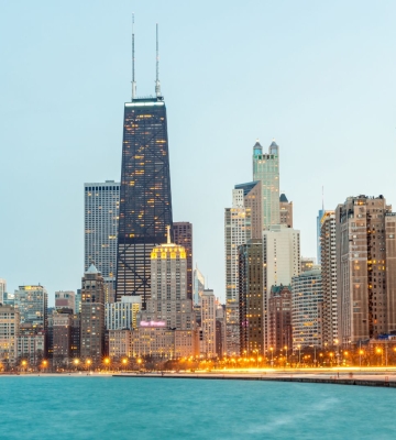 Aerial view of Phoenix neighborhoods with downtown skyline and mountains in the background.