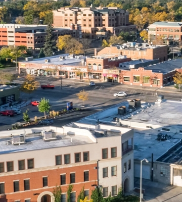 Aerial view of Phoenix neighborhoods with downtown skyline and mountains in the background.