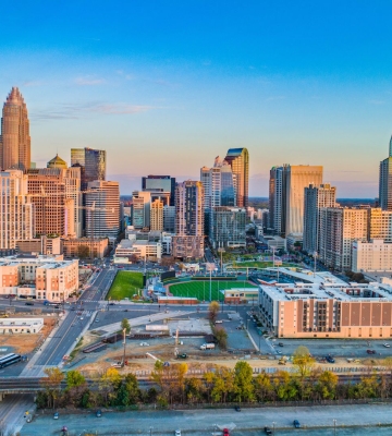 Aerial view of Phoenix neighborhoods with downtown skyline and mountains in the background.