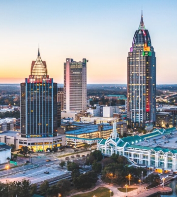 Aerial view of Phoenix neighborhoods with downtown skyline and mountains in the background.