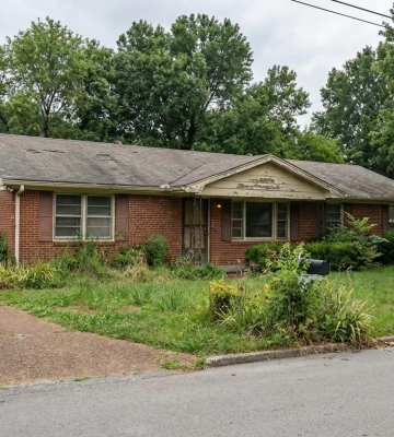 Aerial view of Phoenix neighborhoods with downtown skyline and mountains in the background.