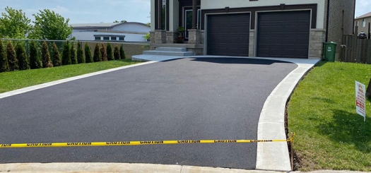 Driveway leading up to a double garage and yellow caution tape.