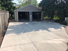 A concrete driveway leading to an open two-car garage.
