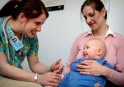 Baby and mother talking with medical professional