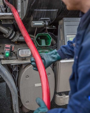 man holding oil refilling hose