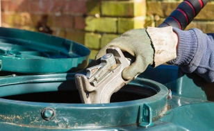 hand holding nozzle filling up kerosene or oil storage container