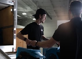 Two people loading equipment into truck
