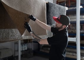 Person cleaning rug and inspecting