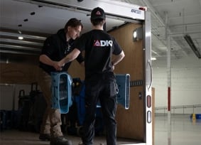 Two people loading equipment into truck
