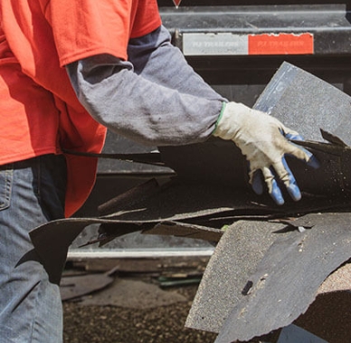 Person discarding roof shingles