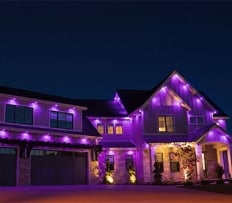 Two story home with colorful purple led lights