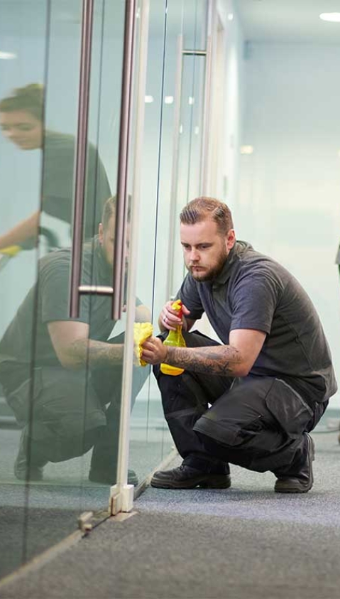 man cleaning glass door