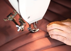 Person working on upholstery on sewing machine 