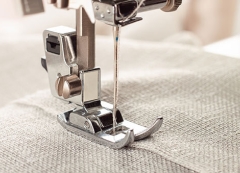 Up close image of sewing machine sewing fabric 