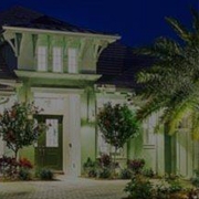 Image of Large White Home at Night with Palm Trees In Yard