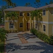 Image of Yellow Home with Palm Trees and Palm Tree Shadows