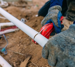 Plumber cutting pvc pipe