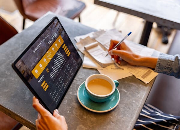 Hands with a pen taking notes from a tablet