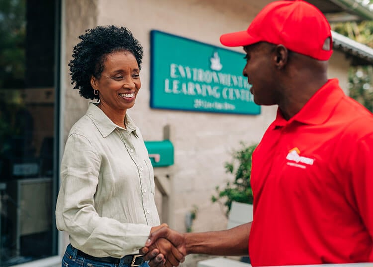 Mr. Handyman employee shaking hands with client