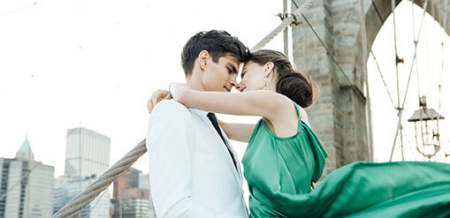 Couple posing in front of bridge