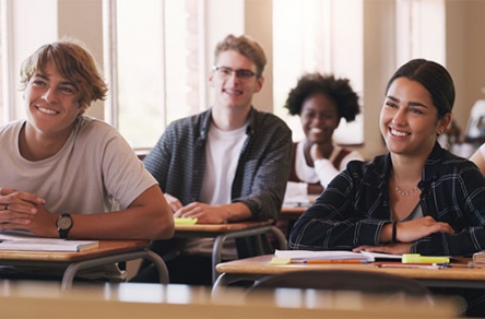 High school students smiling at their desks