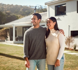 Couple smiling outside home