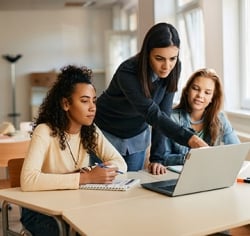 Educator helping two students 