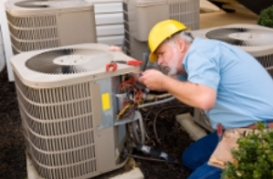 Photo of a technician working on an outside AC