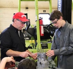 Teacher helping student with engine 
