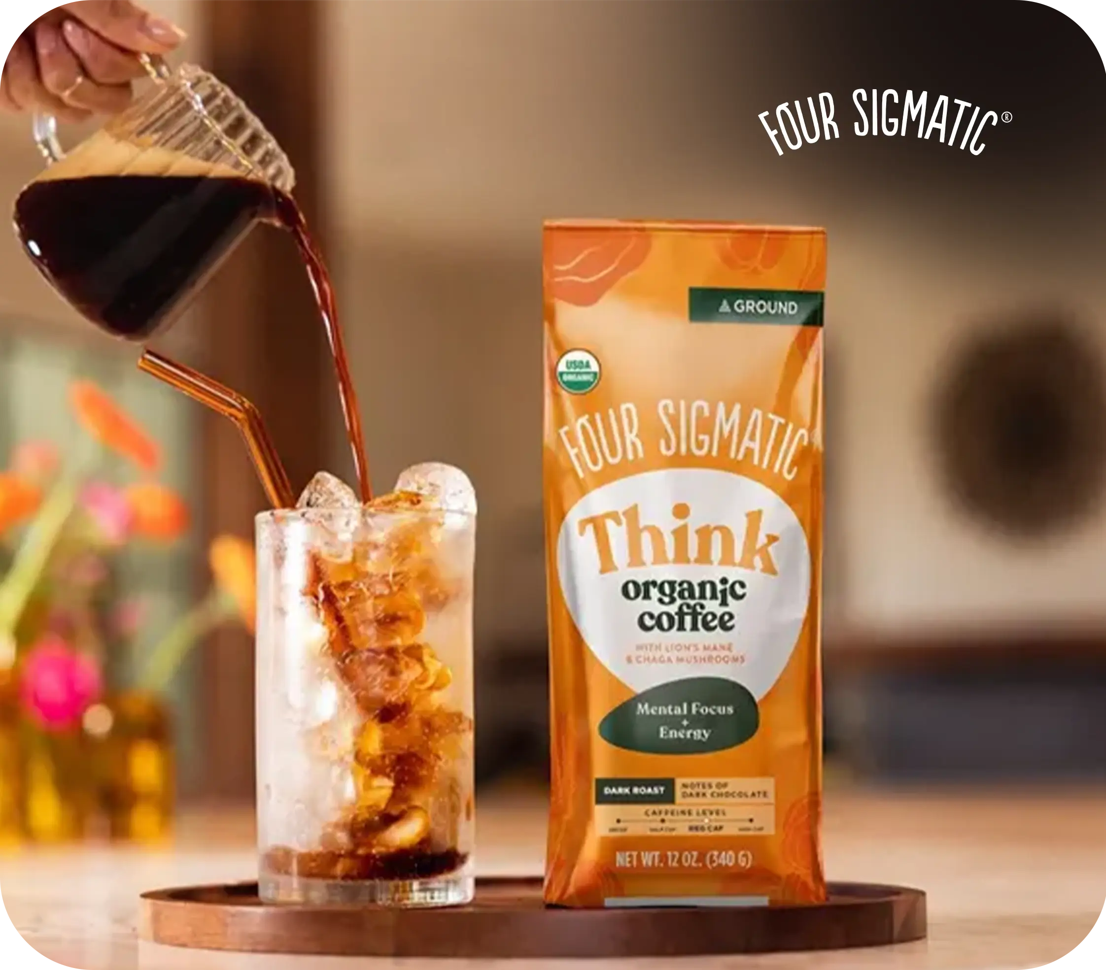 Iced coffee being poured into a glass next to a bag of Four Sigmatic Think organic coffee.