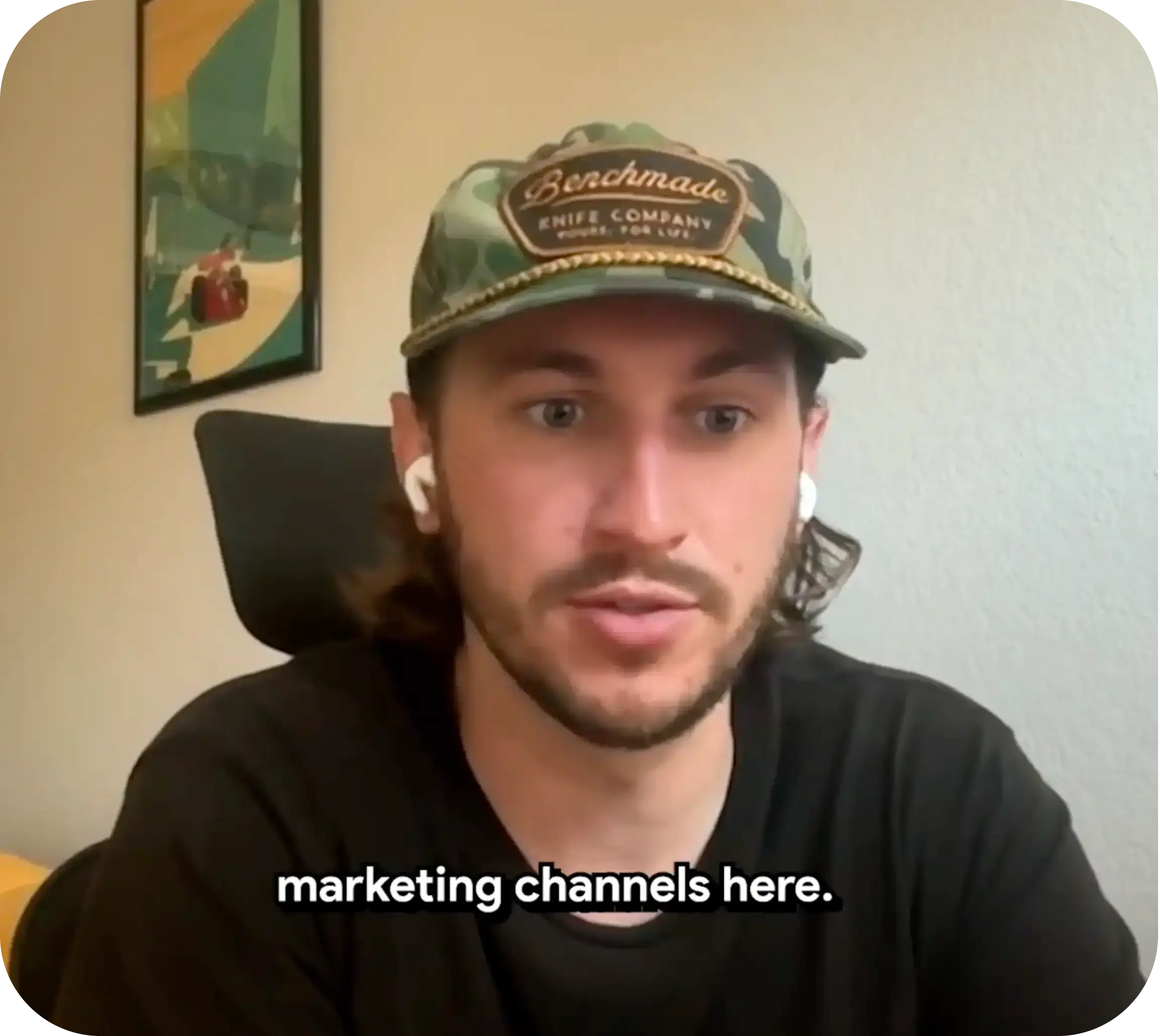 Man in a baseball cap and earbuds speaking on a video call, with on-screen captions.