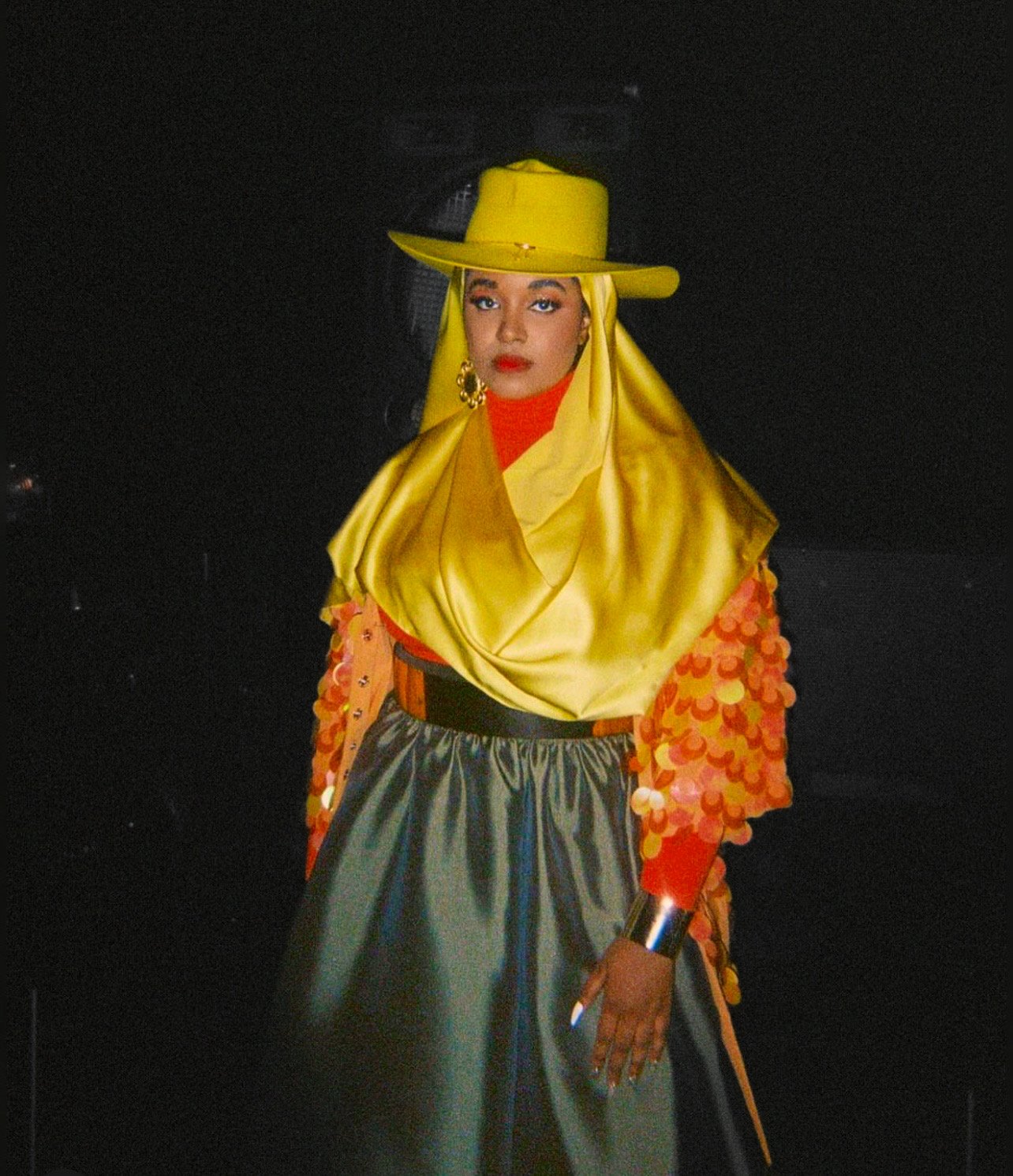 UnitedMasters Amira Unplugged in a bright yellow hat, sequenced yellow top and olive satin skirt