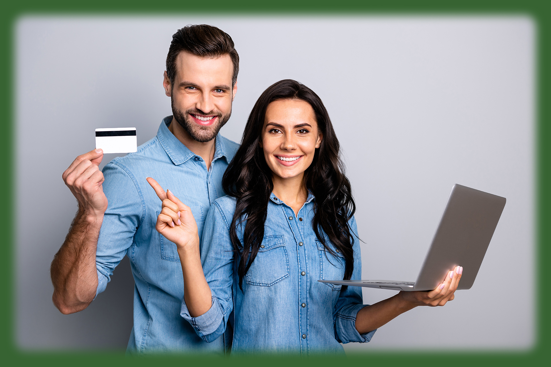 man holding debit card, woman holding laptop and smiling at camera