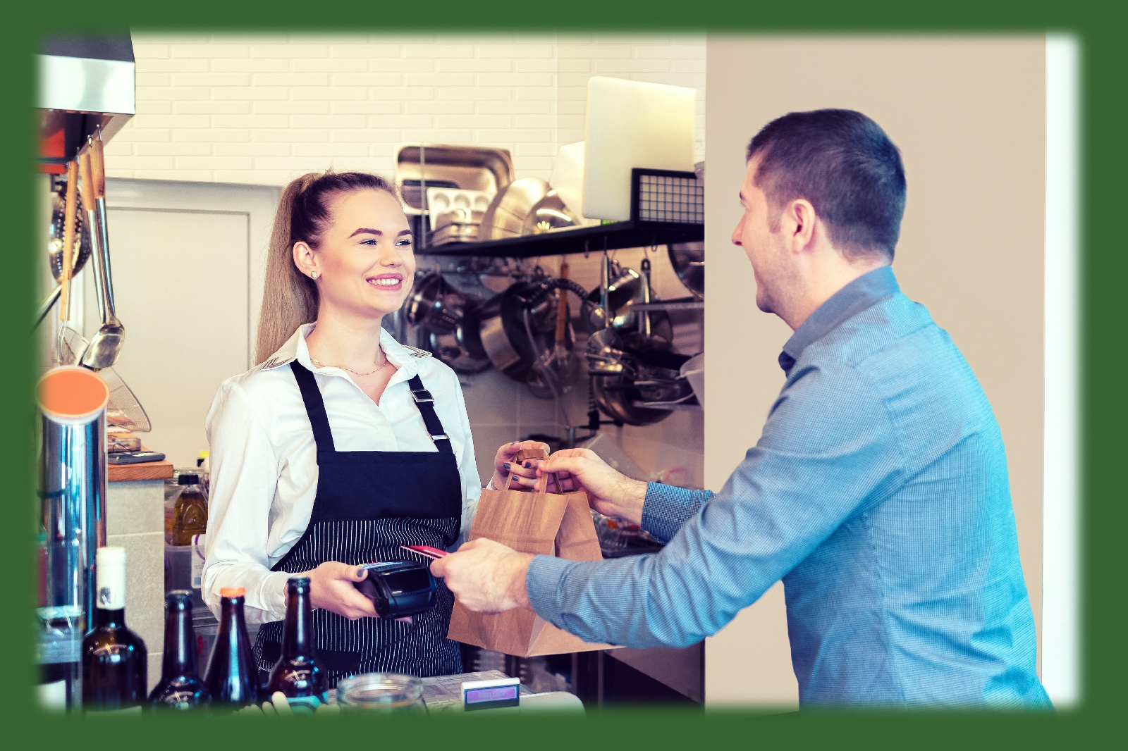 man paying with a debit card while a smiling woman is handing over products
