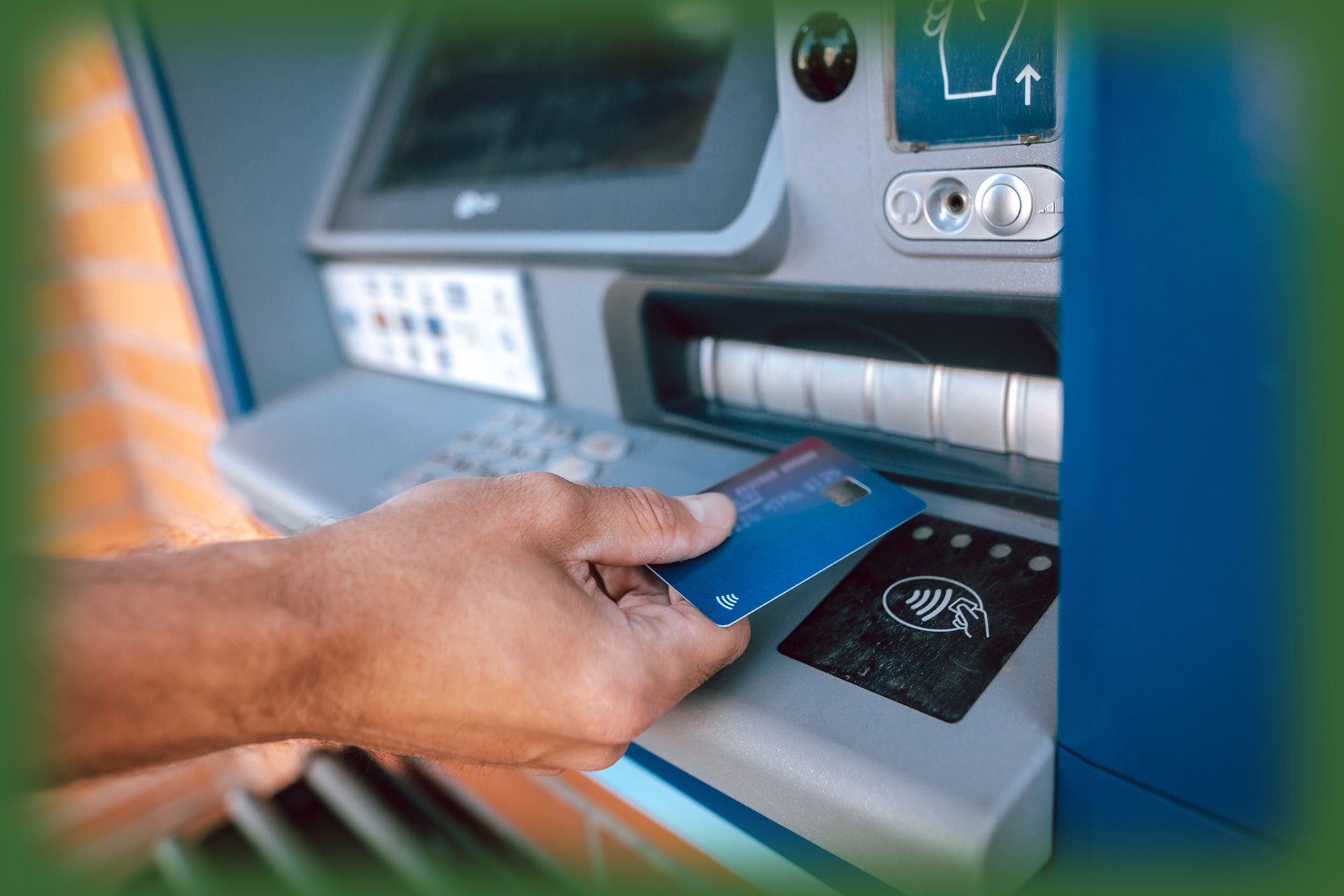 man inserting a debit card into an ATM