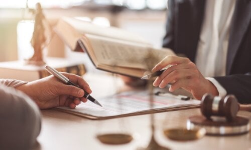 Lawyer and client looking at the law along with documents - estate planning concept