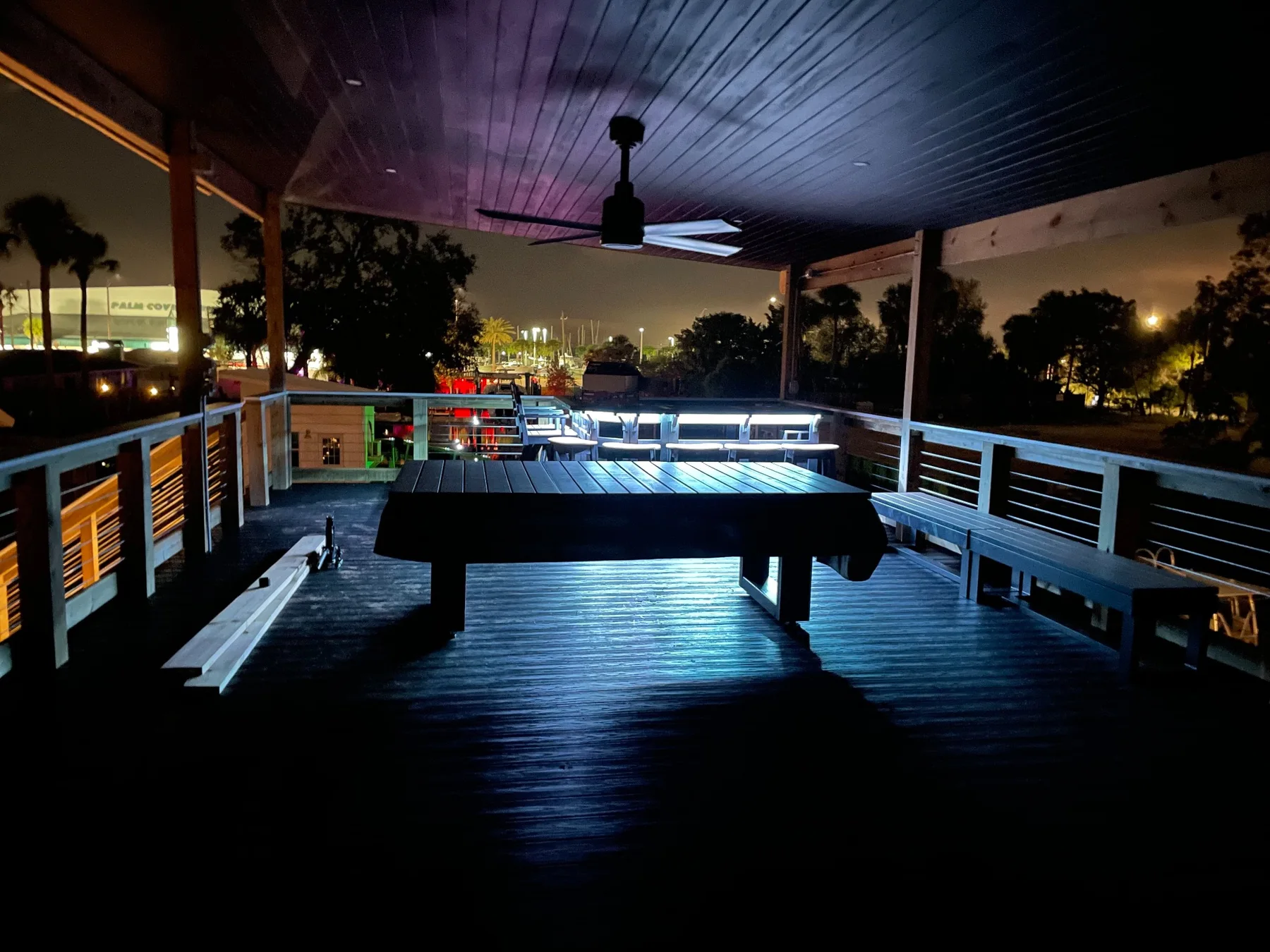 Covered upper dock deck with pool table, benches, fan, and accent lighting