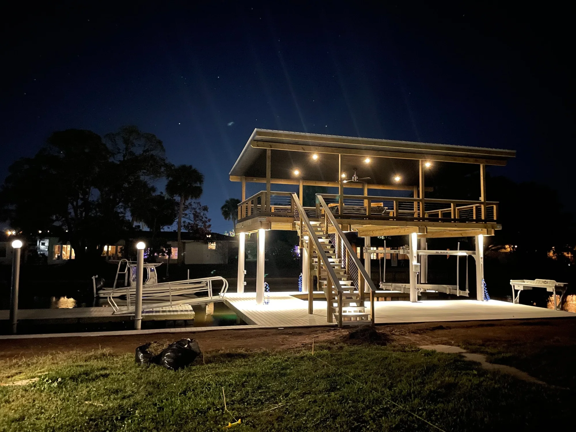 Completed two-level custom dock with covered boat lift and upper waterfront deck in Northeast Florida