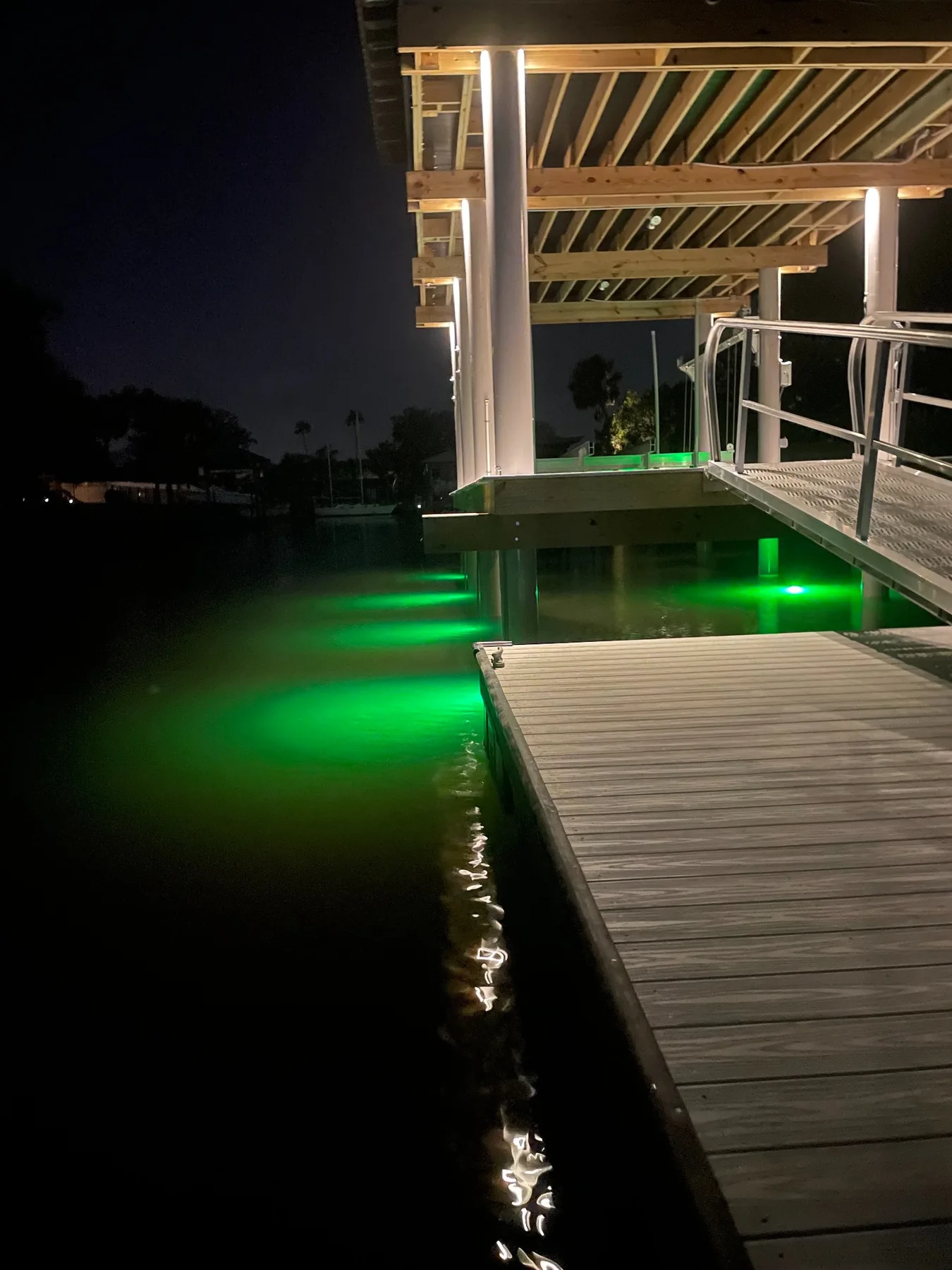 Green underwater dock lights illuminating the water beside a floating dock